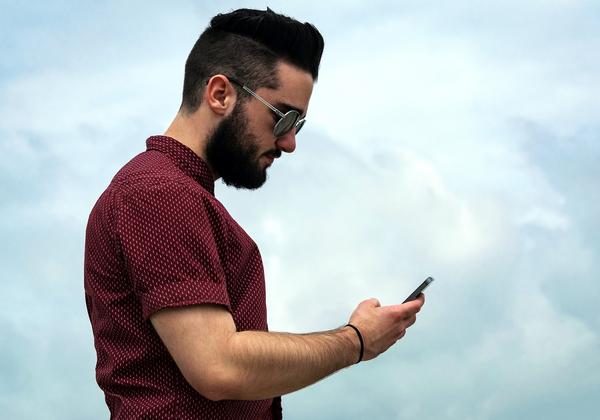 Young Adult Male in profile looking at cell phone