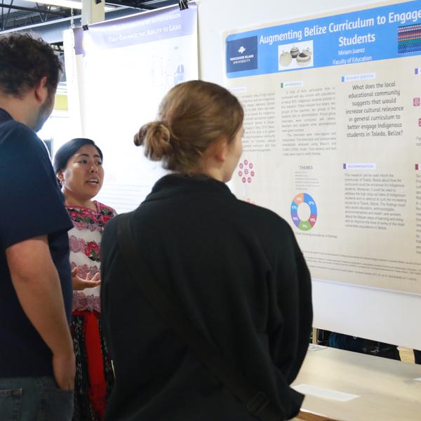 Three students looking at a traditional research poster