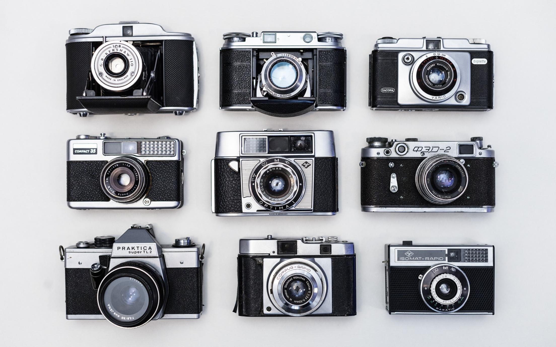 Nine black and silver cameras in a 3 by 3 grid