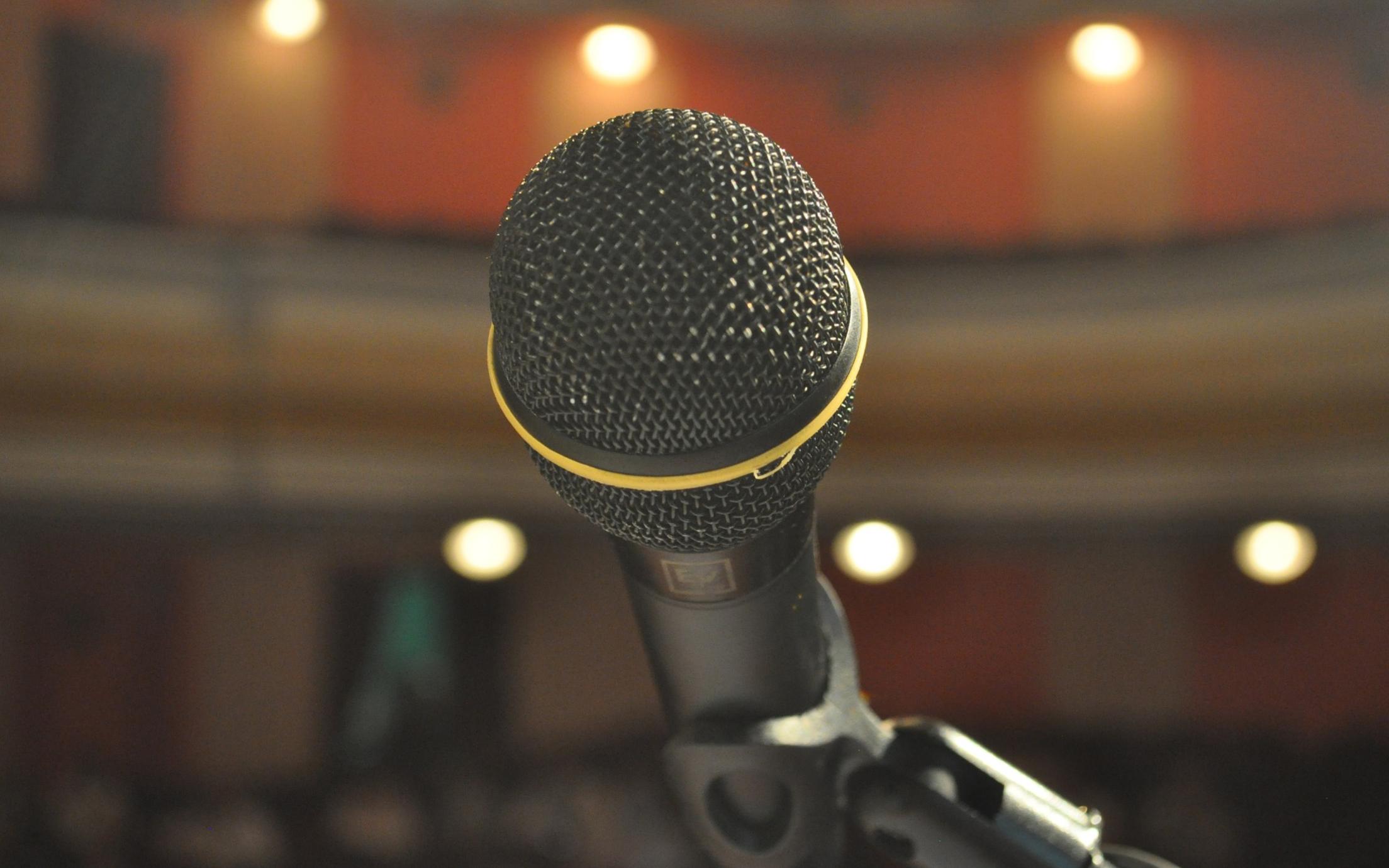 Microphone in focus with out of focus theatre type setting in the background