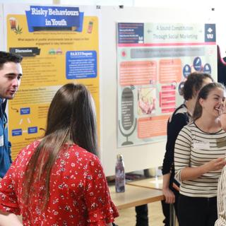 Students around posters at CREATE conference.