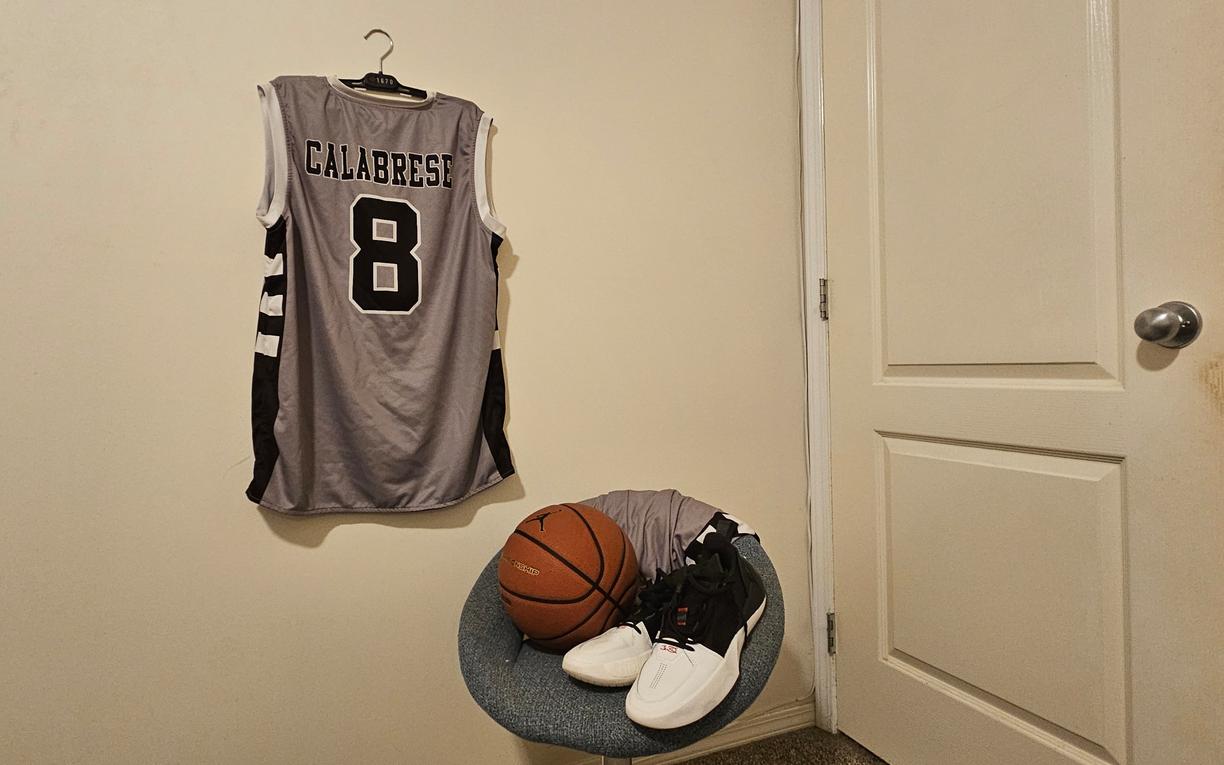 a shirt on the wall and basket ball in a white room