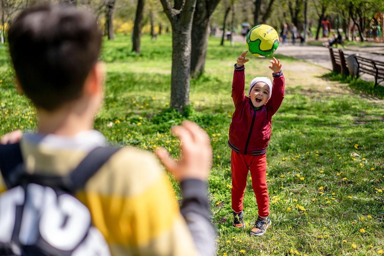 Two kids playing in a green area
