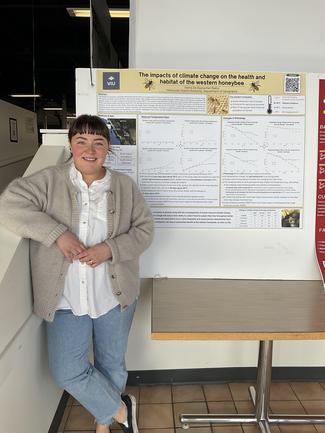 Student standing by poster at CREATE